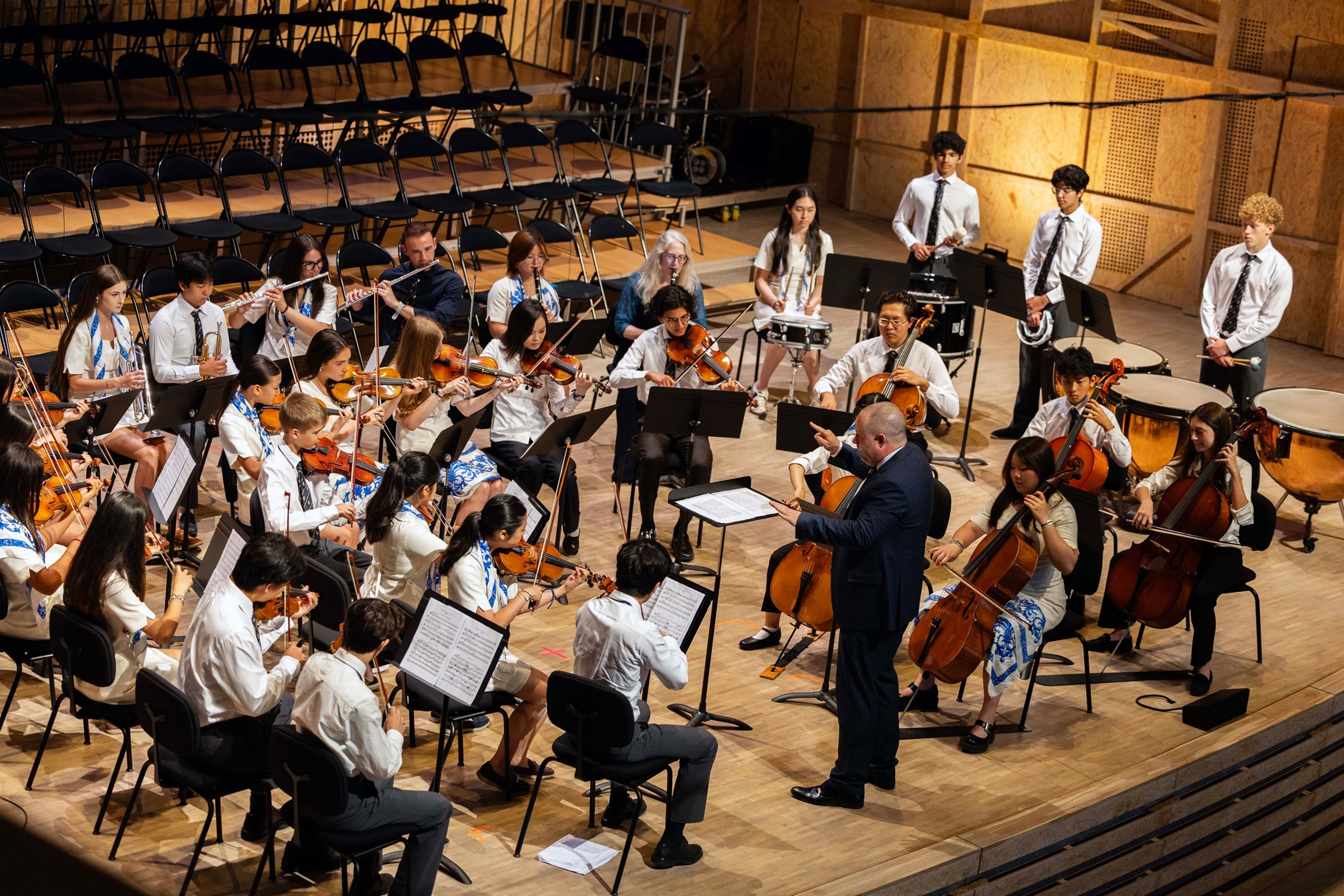The orchestra rehearsing in a concert hall