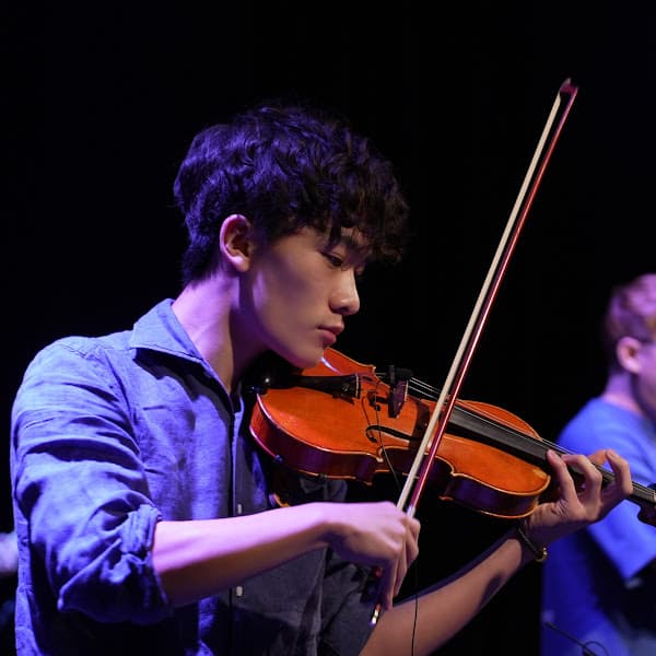 Alan playing violin on stage, close-up